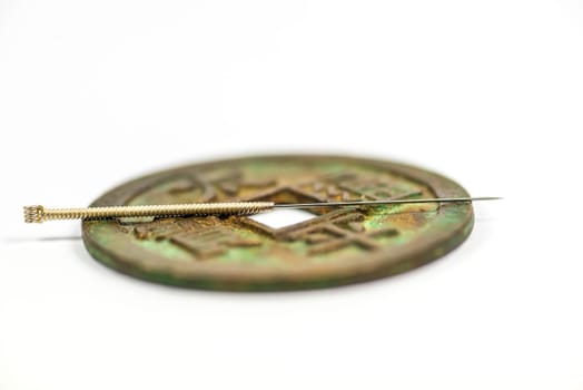 Acupuncture needle on chinese antique coin