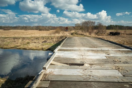Broken plank in a wooden bridge on the river, sunny day, Czulczyce, Poland