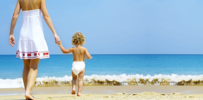 Portrait of young mother with her baby  having fun on the beach