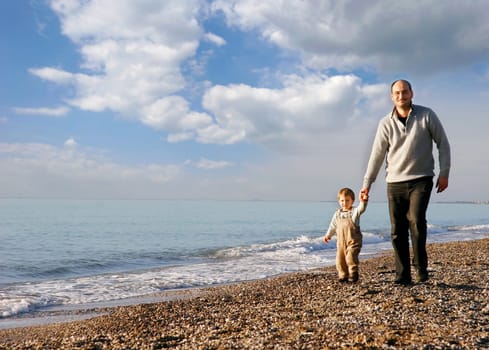 father and son walking on beach