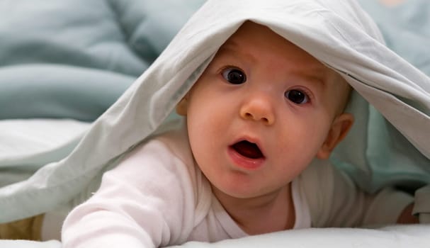 baby that looks shocked playing peak a boo
