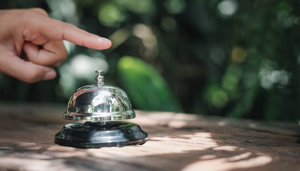 Hospitality hotel. Customer hand ringing service bell at coffee cafe shop for calling the staff to receive the menu, Woman finger touching to ring bell