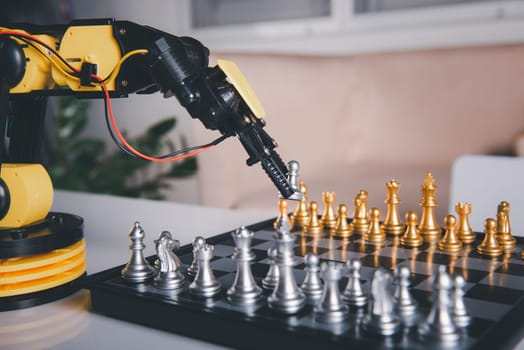 Closeup yellow robot arm playing move chess on chessboard, STEM education E-learning, Technology science robot education concept