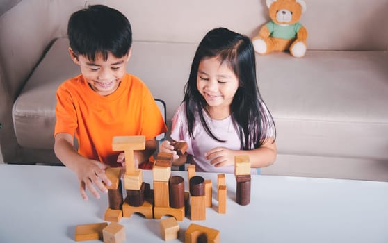 Happy little kids play wood block stacking board game at home, Children boy and girl playing with constructor wooden block, childhood activities learning creative, toys for preschool and kindergarten