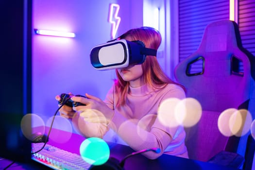Excited woman virtual playing gamepad controller she very determined at home, Gamer in VR headset glasses exploring metaverse play video game online with joystick on computer neon lights
