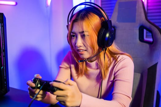 Woman wear gaming headphones playing live stream esports games console at home, Gamer using joystick controller for virtual tournament plays online video game with computer neon lights, Esport concept