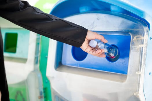 World Environment Day concept. Business woman throwing empty glass  bottle water into recycle garbage trash or bin, Waste management environmental recycling concept