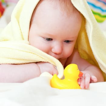 Little baby girl playing with rubber duck