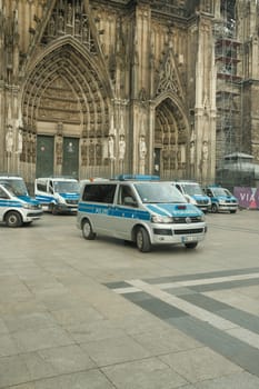 VW Transporter police bus in front of Cologne Cathedral with many police cars in the background