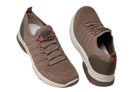 Closeup of a pair of modern brown sneakers or sports shoes isolated on a white background. Elegant and trendy mans shoes. Macro.