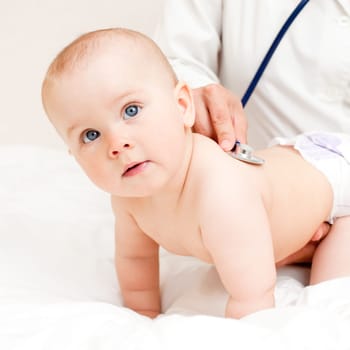 Children's doctor exams infant with stethoscope