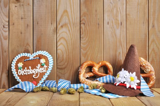 original Bavarian gingerbread heart with Oktoberfest hat and lye brezen in front of old wooden boards