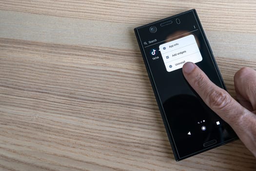 Milan, Italy - 18 10 2022: Uninstalling Tik Tok Application for smartphone. Close up.