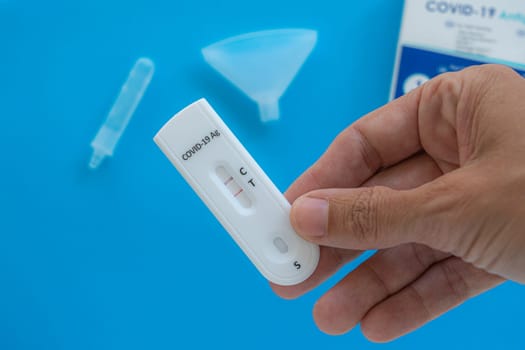 Making Coronavirus Covid-19 antigen test with positive result on white background.