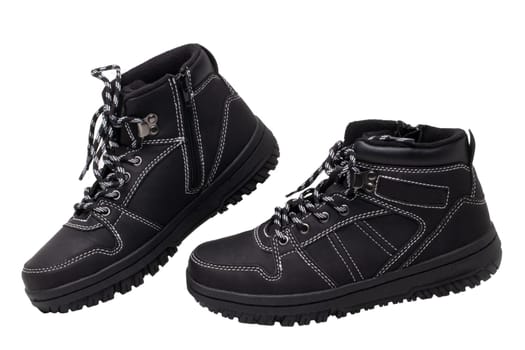 Winter boots. Close-up of a pair elegant black leather winter boots with laces and rivets isolated on white. Macro. Autumn shoe fashion for child boy.