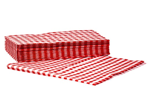 Closeup of a stack of red checked or checkered paper napkins isolated on a white background. Clipping path. Macro. Stacked towel or tablecloth.