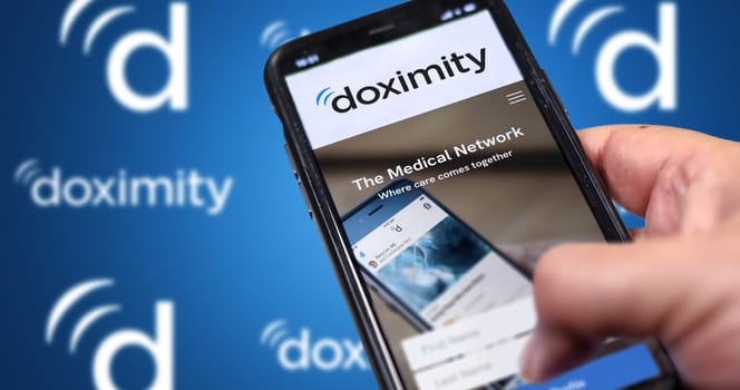 San Francisco, CA, USA March 2022: Doximity company website on a phone screen. Blue background with repeated Doximity logo blurred in the background. Illustrative editorial. Selective focus.