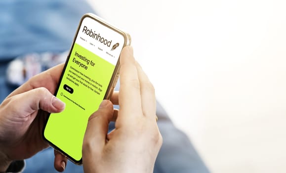 Menlo Park, CA, USA, April 2021: Female hands hold a smart-phone with the Robinhood app on the screen. Robinhood is a financial american services company. Illustrative editorial