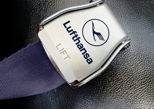 Munich, DE, July 2022: detail of the buckle of the seat belt with the logo of Lufthansa airlines on an empty seat. Lufthansa is the flag carrier of Germany. Illustrative editorial