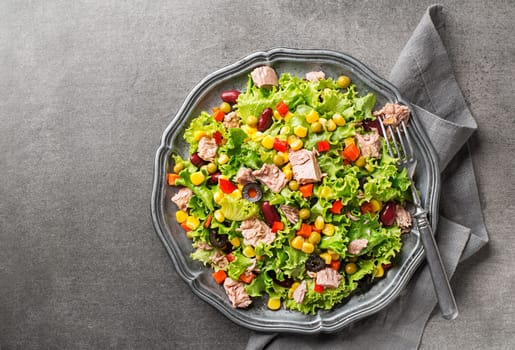 Healthy Green salad with tuna and vegetable on grey table background. Mexican corn salad.