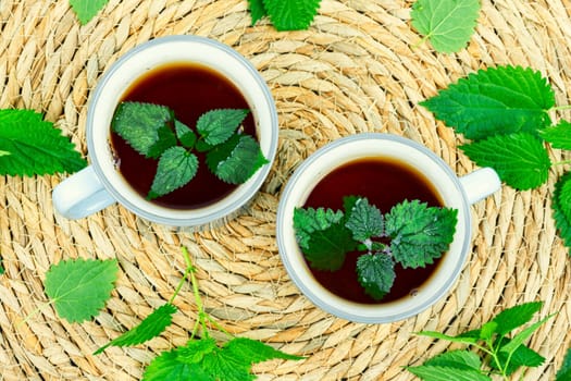 Teacup with herbal tea, healing tea with fresh nettle. Homeopathy, herbal medicine.