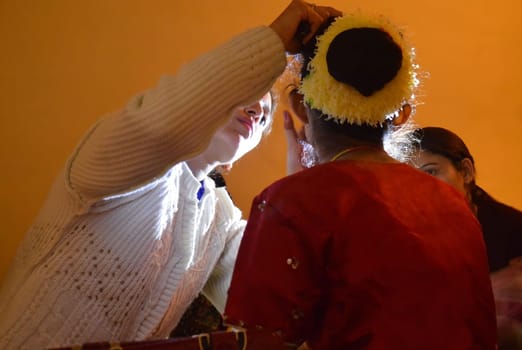A young bride gets wedding make-up done by her sisters