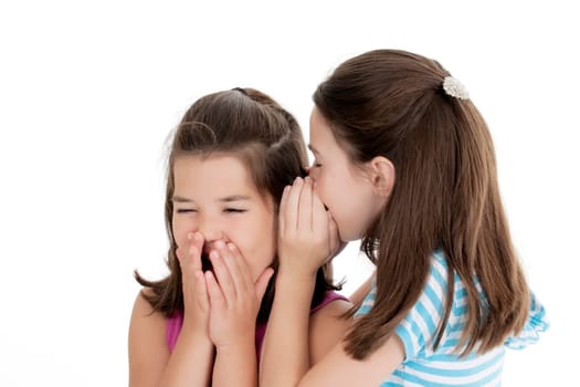 Two Caucasian girls telling secrets on white background