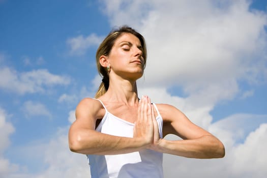 Pretty woman in white doing yoga outdoor