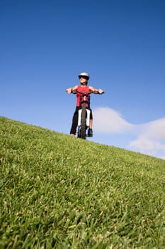 Women with mountain bicycle on the top of a hill