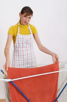 woman hanging towels on the rack, shot over white