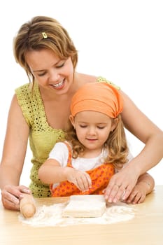 Woman teaching little girl how to stretch the dough making a cake - isolated