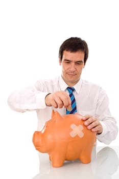 Businessman putting money in his wounded piggy bank - isolated