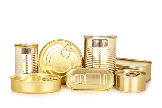 Assortment of golden food tin can reflected on white background