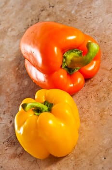 Yellow and orange paprika on a stone counter