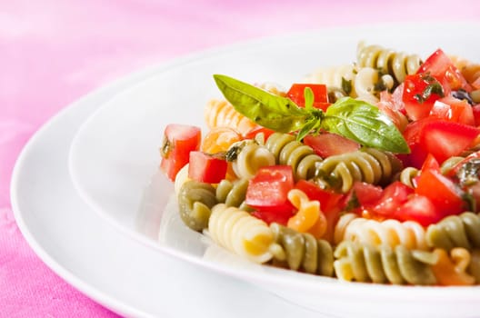 Pasta primavera garnished with basil leaves