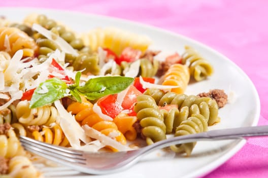 Pasta primavera garnished with basil leaves