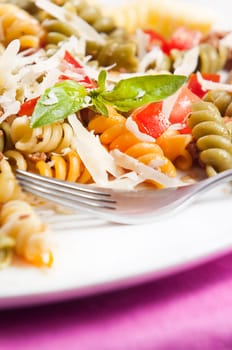 Pasta primavera garnished with basil leaves