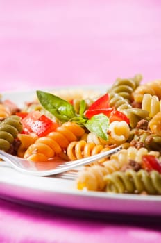 Pasta primavera garnished with basil leaves