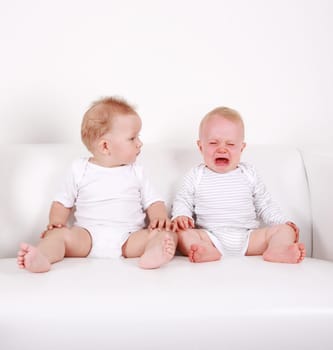 Two swert babies - one looking, one crying