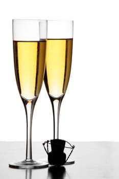 Two champagne glasses and a cork in silhouette