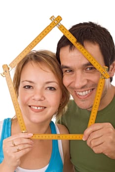 Young couple with model house of wooden meter