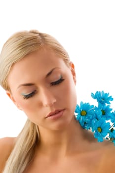 pretty blond girl in a beauty portrait with blue daisy on her shoulder.