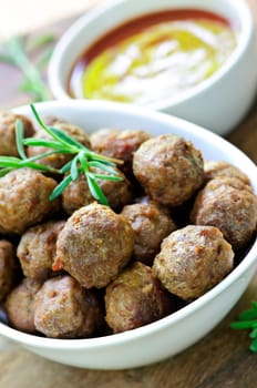 Fresh hot meatball appetizers served in white bowl with dipping sauce