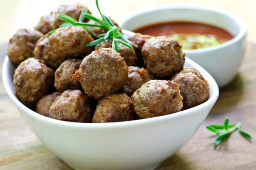 Fresh hot meatball appetizers served in white bowl with dipping sauce