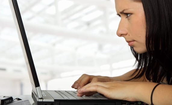 close-up of a female working profoundly on a laptop, serious