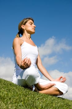 Pretty woman in white doing yoga outdoor