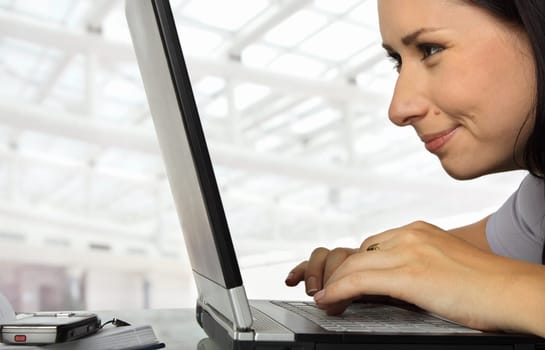 close-up of a female working profoundly on a laptop, smiling