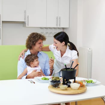family eating meat fondue at home. Copy space