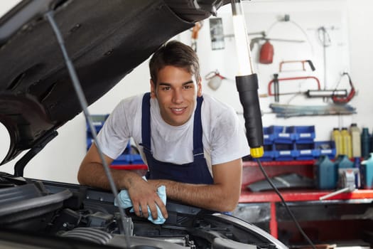 mechanic leaning on bonnet and looking at camera