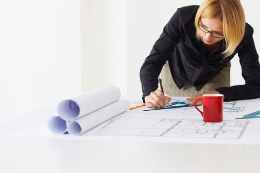 portrait of female architect drawing line on blueprint. Copy space